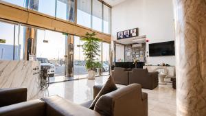 a lobby with couches in a building with windows at توارن للشقق المخدومة - اقتصادي in Hail