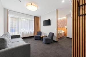 a living room with a couch and two chairs at Värska Veekeskuse hotell in Väike-Rõsna
