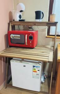 a microwave sitting on a shelf next to a refrigerator at Casa Gracia in Granda