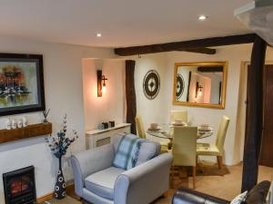 a living room with a table and a chair and a fireplace at Byways in Cartmel