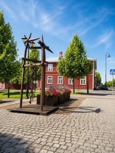 a statue of a cross in front of a red building at Katariina allee korter in Võru