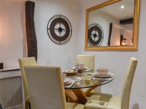a dining room with a table with chairs and a mirror at Byways in Cartmel +10 photos