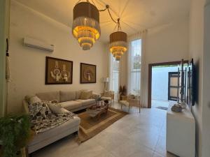 a living room with a couch and two chandeliers at Villa danexia in Juan Dolio