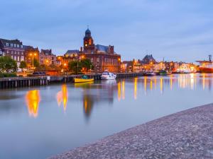 a river with buildings and boats in a city at night at Rosemary - E4484A in Catfield +1 photo