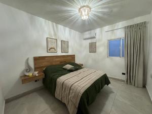 a bedroom with a bed and a chandelier at Villa danexia in Juan Dolio +13 photos