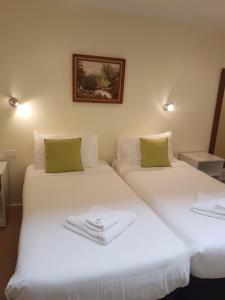 a hotel room with two beds and two lamps at Getaway Inn Boutique Guest house in Nulkaba