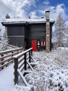 a building with a red door in the snow at Vikinggrenda 5C - walking distance to everything - ski in and out in Trysil