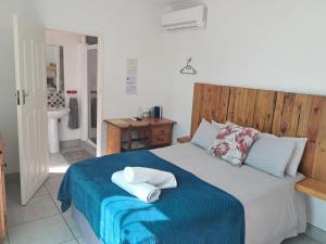 a bedroom with a bed with two towels on it at Ons Dorpshuis Beaufort West in Beaufort West