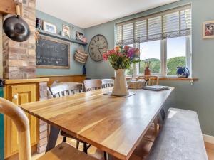 a dining room table with a vase of flowers on it at Pen Y Groes in Welshpool
