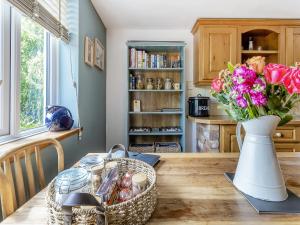 a kitchen with a table and flowers in a vase at Pen Y Groes in Welshpool