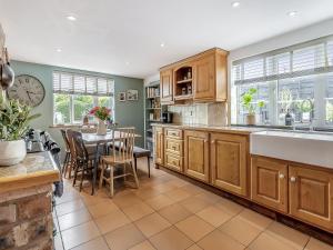 a kitchen with wooden cabinets and a dining room with a table at Pen Y Groes in Welshpool