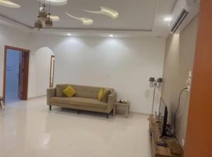 a living room with a couch on a white wall at الوجه مخطط 110 in Al Wajh