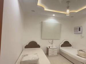 a bedroom with two beds and a white wall at الوجه مخطط 110 in Al Wajh
