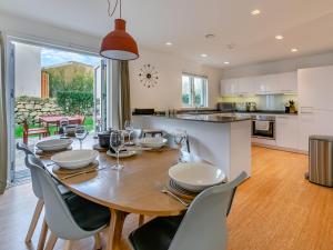 a kitchen and dining room with a wooden table and chairs at Lodge 53 Una in Carbis Bay