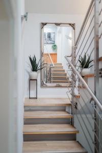 a stairway with a mirror and potted plants at MAISON ART Appartements - Objekt 94080 in Warnemünde