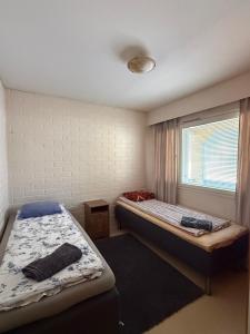 a bedroom with two beds and a window at Loft house Karihaara in Kemi