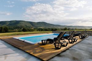 a group of chairs sitting on a deck next to a swimming pool at Brvnara Staničić sa privatnim bazenom in Arandelovac