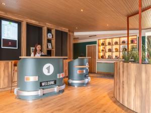 a woman standing at a counter in a room at ibis Styles Lyon Sud Vienne in Chasse-sur-Rhône