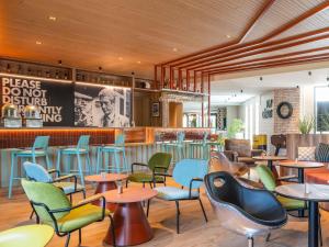 a restaurant with tables and chairs and a bar at ibis Styles Lyon Sud Vienne in Chasse-sur-Rhône