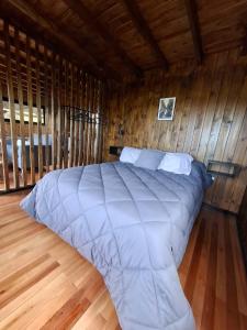 a bedroom with a large bed in a wooden room at Irupecita Refugio Isleño in Victoria
