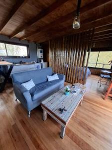 a living room with a blue couch and a coffee table at Irupecita Refugio Isleño in Victoria
