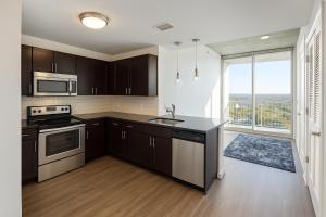 a kitchen with brown cabinets and a large window at Condo in downtown oak city highrise in Raleigh