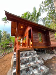 a small wooden house with a stone step leading up to it at Fuma Bungalow Tetebatu in Tetebatu