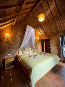 a bedroom with a large bed in a room at Fuma Bungalow Tetebatu in Tetebatu