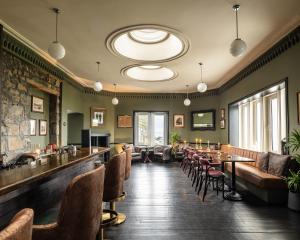 a restaurant with a bar and tables and chairs at Flodigarry Hotel in Staffin