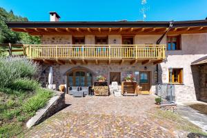 a house with a balcony and a patio at Agritur Maso Bornie in Grauno