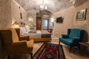 a bedroom with a bed and two chairs at Aren Cave Hotel And Art Gallery in Göreme