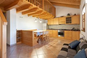 a kitchen with wooden cabinets and a table with chairs at Agritur Maso Bornie in Grauno