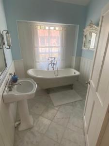 a bathroom with a tub and a sink at Lavender Cottage in Long Bennington