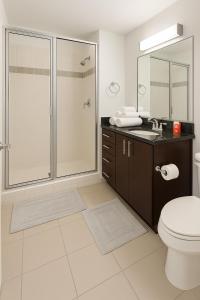 a bathroom with a shower and a toilet and a sink at Condo in downtown oak city highrise in Raleigh +3 photos