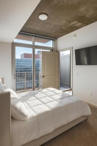 a bedroom with a large bed and a large window at Condo in downtown oak city highrise in Raleigh