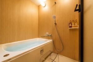 a bathroom with a bath tub and a shower at 緑翠-Ryokusui- in Beppu +11 photos