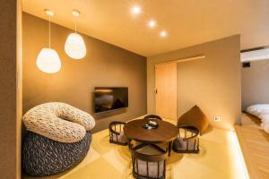 a room with a chair and a table and a bed at 緑翠-Ryokusui- in Beppu