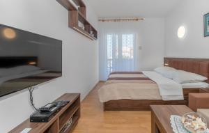 a bedroom with a bed and a large flat screen tv at Apartmani s dvije spavaće sobe 4 osobe in Selce