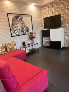 a living room with a red couch and a tv at Urban Home in Pompei