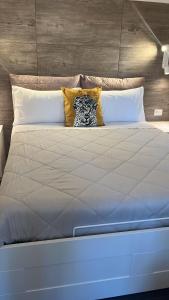 a large white bed with a pillow on it at Urban Home in Pompei