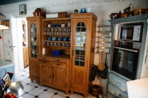 a large wooden cabinet with glass doors in a kitchen at Landhaus Hüttblek in Hüttblek +67 photos