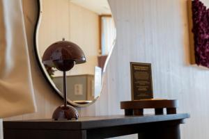 a mirror on a table with a lamp on it at Bella Lake Resort in Kuopio