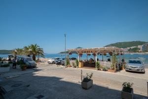 a parking lot with cars parked next to the water at Andrej Apartmani Rafailovici in Rafailovici