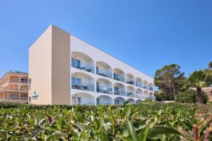 an apartment building with grass in front of it at Universal Casa Marquesa in Colònia de Sant Jordi