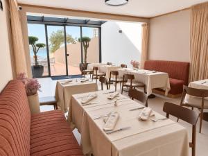 ein Restaurant mit Tischen und Stühlen und einem großen Fenster in der Unterkunft Hotel Vallum by St Pietro in Cavtat