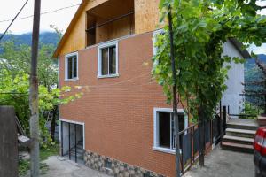 a red brick building with white windows and stairs at Guest House Mercury in Khulo