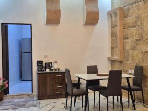 a kitchen with a table and chairs and a refrigerator at Heart of Jerash in Jerash