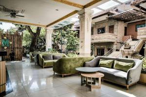 a living room with couches and a table at Melasti Kuta Beach Hotel & Spa in Kuta