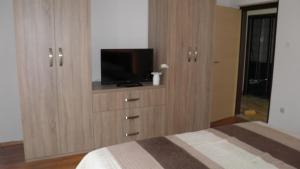 a bedroom with a large wooden cabinet with a tv on it at APP 4+1 s dvije spavaće sobe in Selce