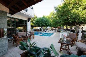 a patio with chairs and a swimming pool at Kutberk Hotel Kemer in Kemer